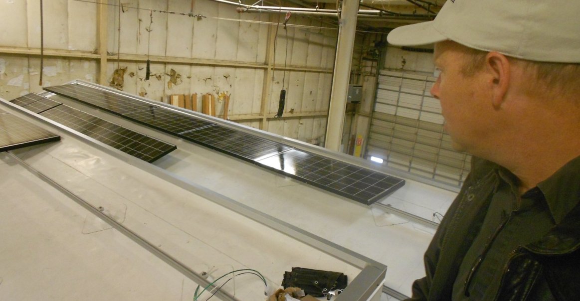 Solar panels get installed at the factory for a commercial project.