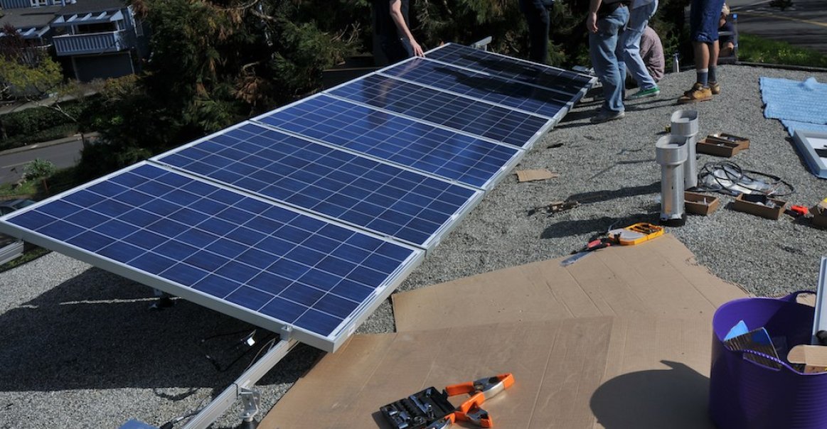 Microinverters and panels being installed on the rails